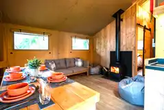 Maple safari tent living area with a fire place and furniture