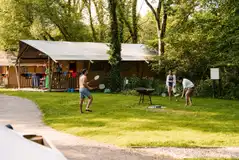 Safari tents with a fire pit and space for outdoor games