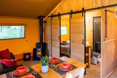 Lime and Rowan safari tent dining area with a fire place