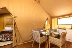 Four person safari tent interior seating area and kitchenette