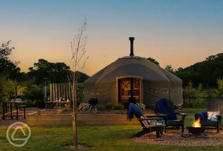 Hadrian's Wall Country Yurts at night with a fire pit and hot tub