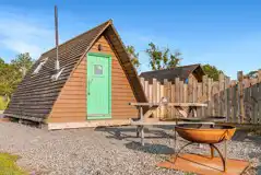 Camping with a private outdoor space with seating, a table and fire pit