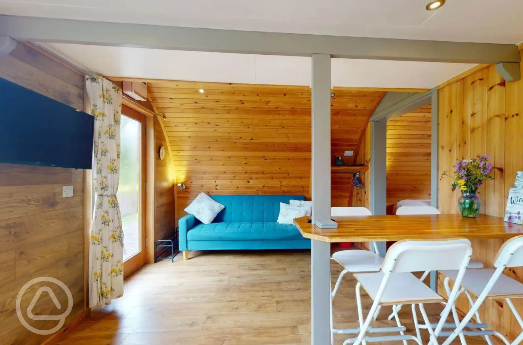 Blossom glamping pod - interior with a TV and sofa bed
