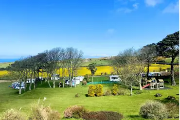 Overview of Gadlys Touring Park set amongst trees with a play park