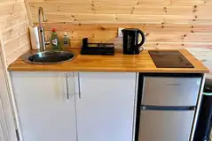 Luxury pod kitchen with a hob, kettle, microwave, fridge/freezer and sink Luxury pod kitchen with a hob, kettle, microwave, fridge/freezer and sink