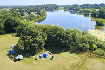 Grass pitches by the Great Lake, tucked behind the trees