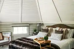 Mawgies glamping cabin with a king size bed and bedding