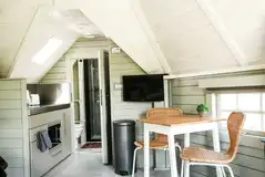 Mawgies with a TV, dining area and kitchen with a microwave/oven, sink and hob