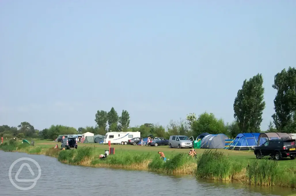 Electric grass tent and touring pitches by the lake at Grange Leisure Park
