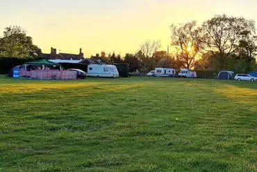 Campers and tourers on the camping field at sunset