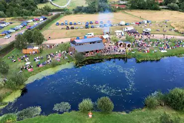 Overview of Old Buckenham Country Park with lake, cafe, and grass pitches