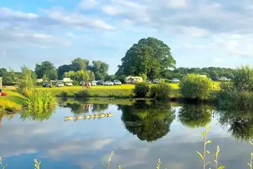 Overview of Old Buckenham Country Park with a lake and distant pitch views