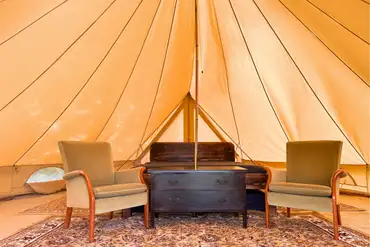 Bell tent interior with king size bed, twin beds, and room for extra bed