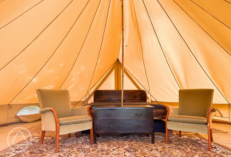 Bell tent interior with king size bed, twin beds, and room for extra bed