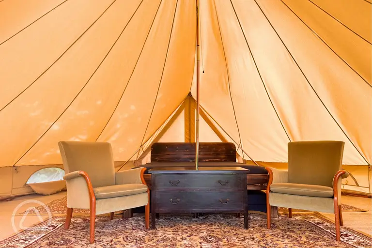Bell tent interior with king size bed, twin beds, and room for extra bed