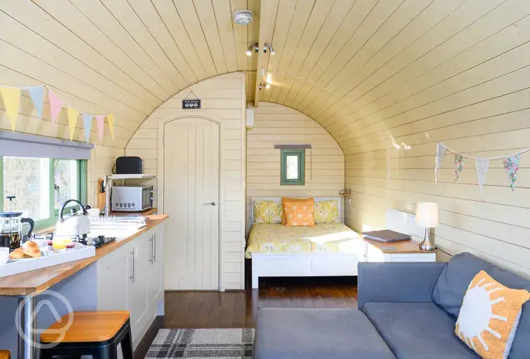 Glamping pod interior with double bed, sofa bed, and ensuite at Galloway Hills