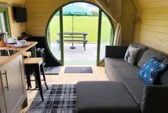 Standard glamping pod interior with sofa bed, seating and countryside views Standard glamping pod interior with sofa bed, seating and countryside views