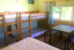 Primrose cabin with a double bed, two bunk beds, a table and chairs