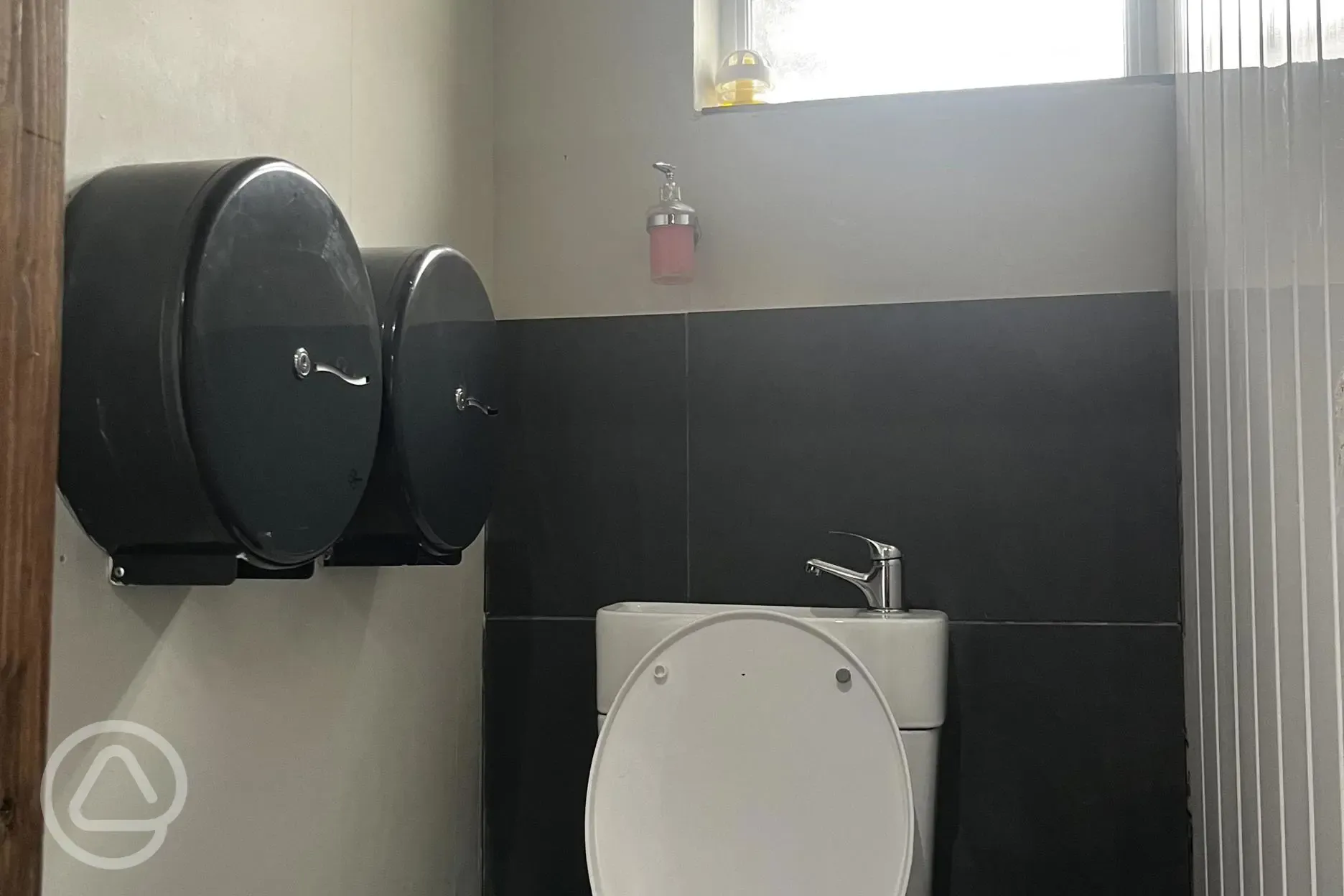 Private toilet cubicle with a hand washing sink