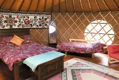 Bramble yurt interior featuring a double abed and single sofa bed