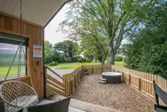 Stargazer glamping cabin outdoor area with a fenced garden and hot tub