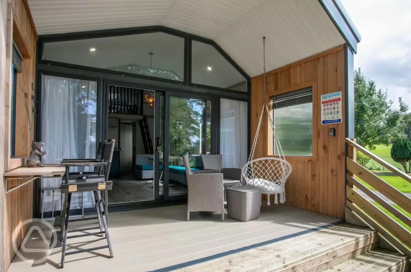 Stargazer glamping cabin decking with a table, chairs and swing seat