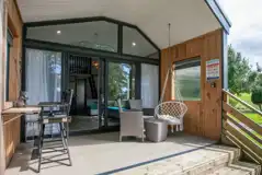 Stargazer glamping cabin decking with a table, chairs and swing seat