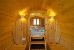 Camping pod interior with a raised bed and bench seating