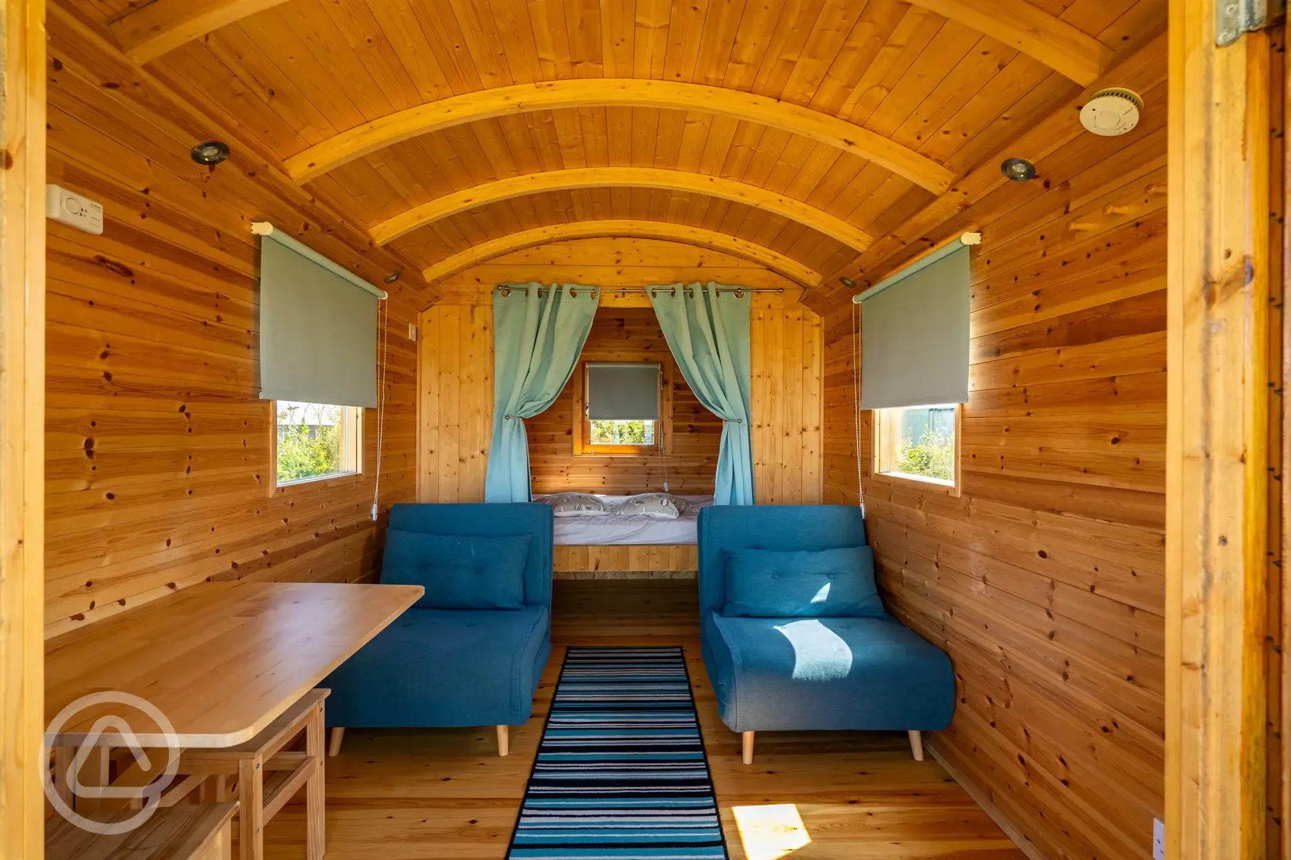 Shepherd's hut interior with a double bed and two single futon beds