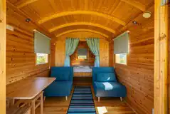 Shepherd's hut interior with a double bed and two single futon beds