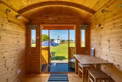 Shepherd's hut interior with a table and chairs, plus a small outdoor decking