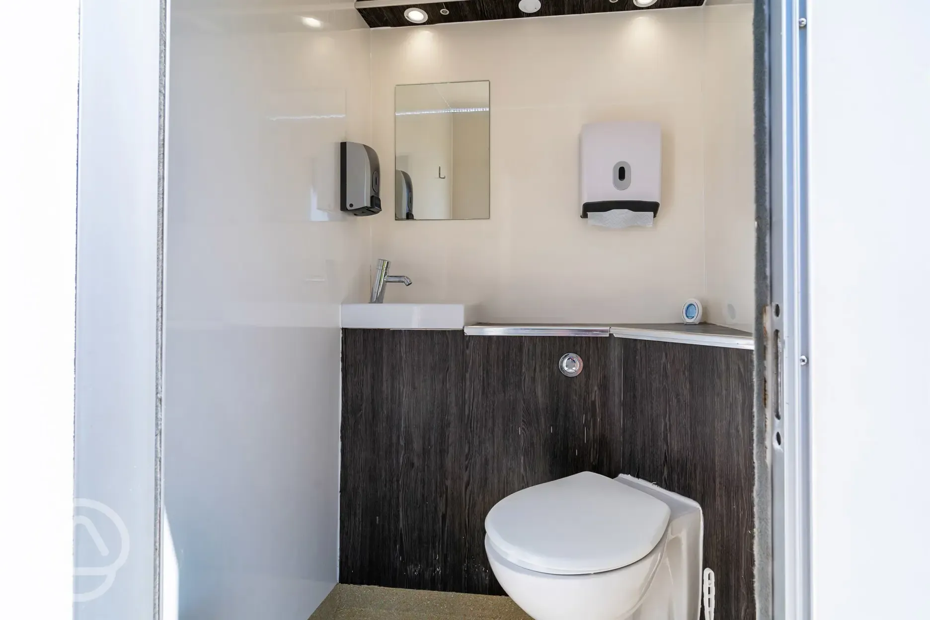 Private toilet cubicles with a hand basin, mirror and paper towels