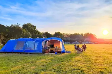 Non electric grass tent pitch at sunset