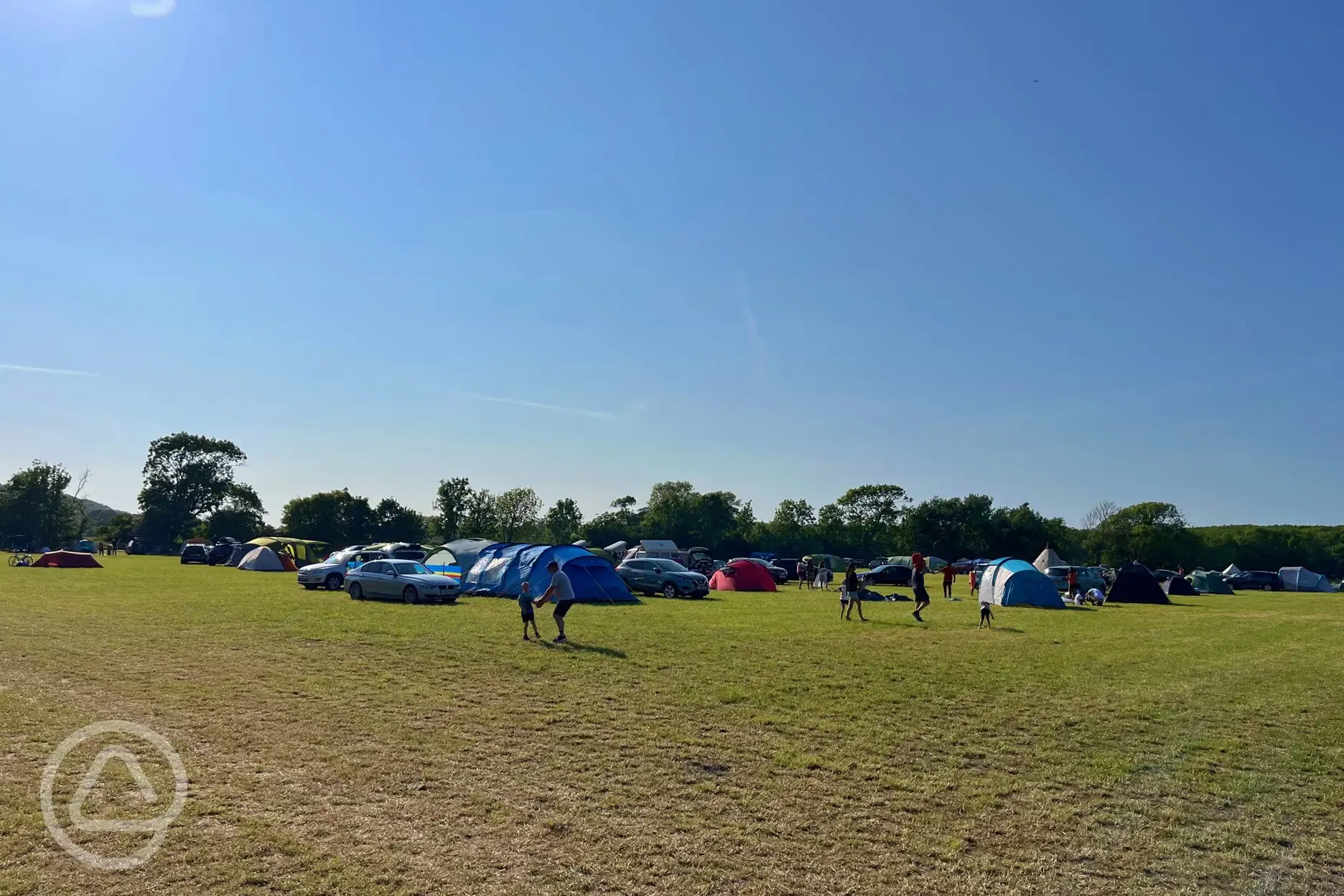 Non electric grass pitches with parking spaces beside tents