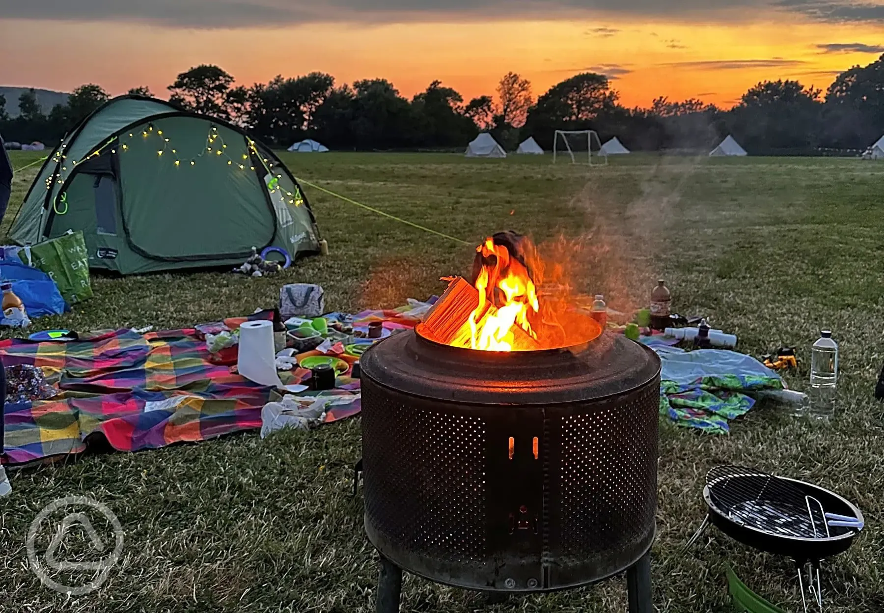 Campsite at night with fire pits and sunset