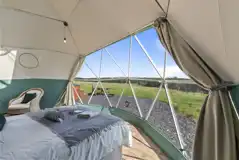 Aries geodome interior with a king sized bed and countryside views
