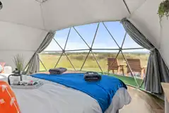 Orion geodome interior with a king size bed and countryside views