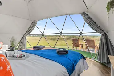Orion geodome interior with a king size bed and countryside views