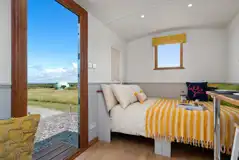 Heather shepherd's hut interior with double bed