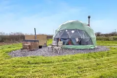 Orion geodome exterior with a private hot tub and bathroom cabin
