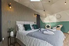 Aries geodome interior with a king sized bed and seating area