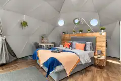 Orion geodome interior with king size bed and kitchen area behind