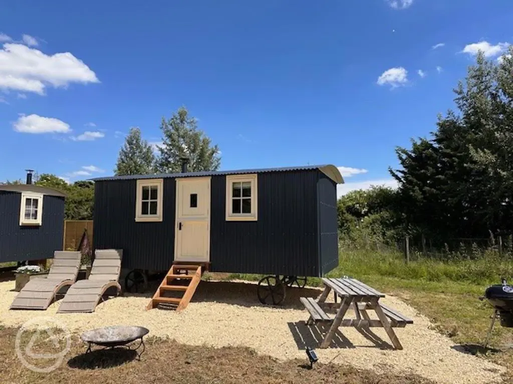 Shepherd's huts with sun loungers, a picnic table, and fire pit 