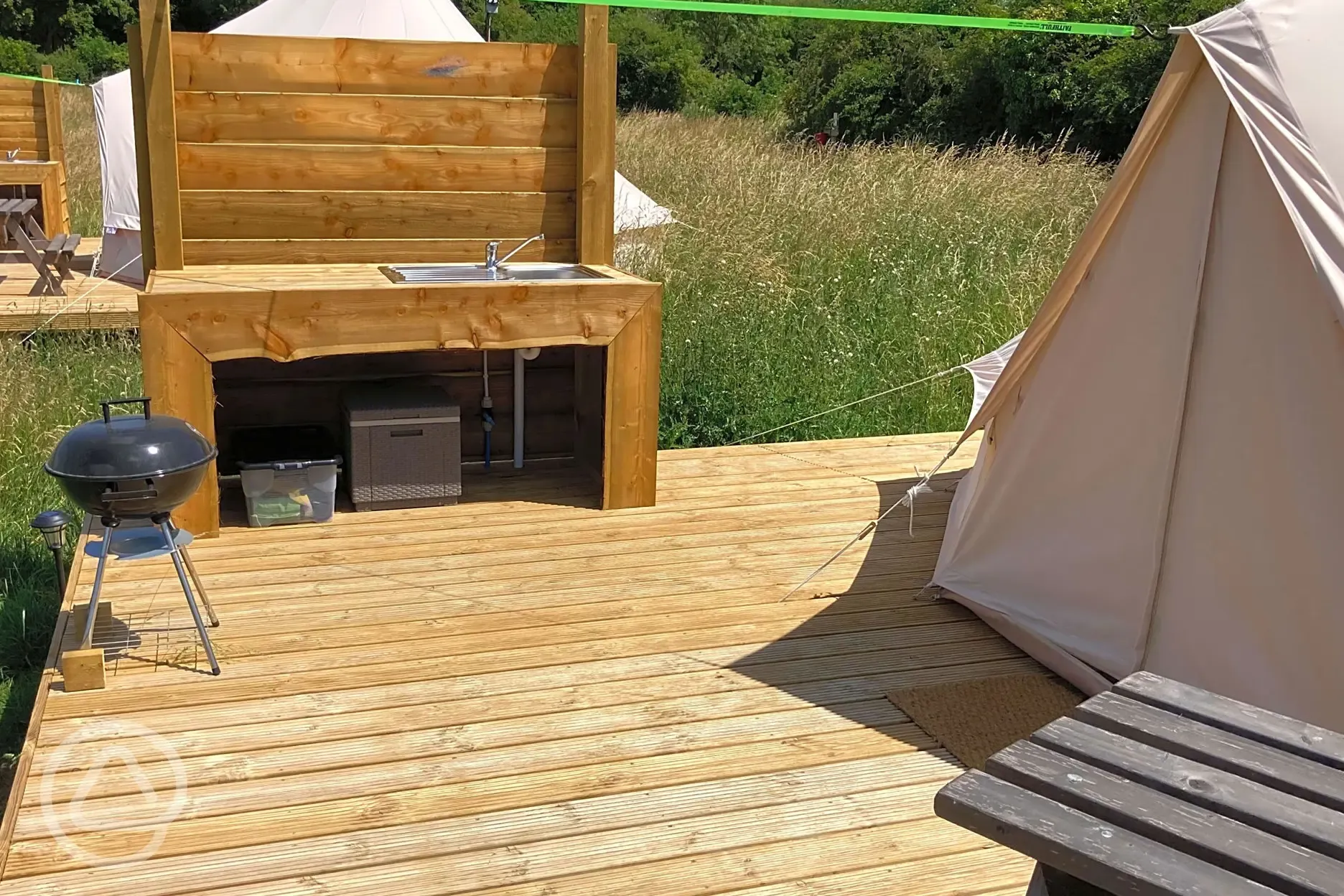 Bell tent decking with BBQ and washing up area