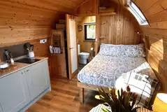 Bracken glamping pod interior with a double bed, kitchen and ensuite