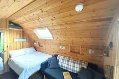 Willow glamping pod interior with a double bed and sofa bed