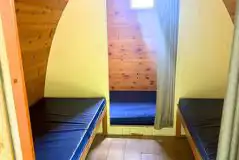 Camping pod interior with a double mattress and two single beds Camping pod interior with a double mattress and two single beds