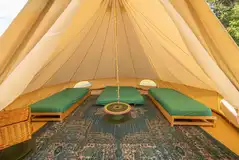 Bell tent interior with futon mattresses and furniture