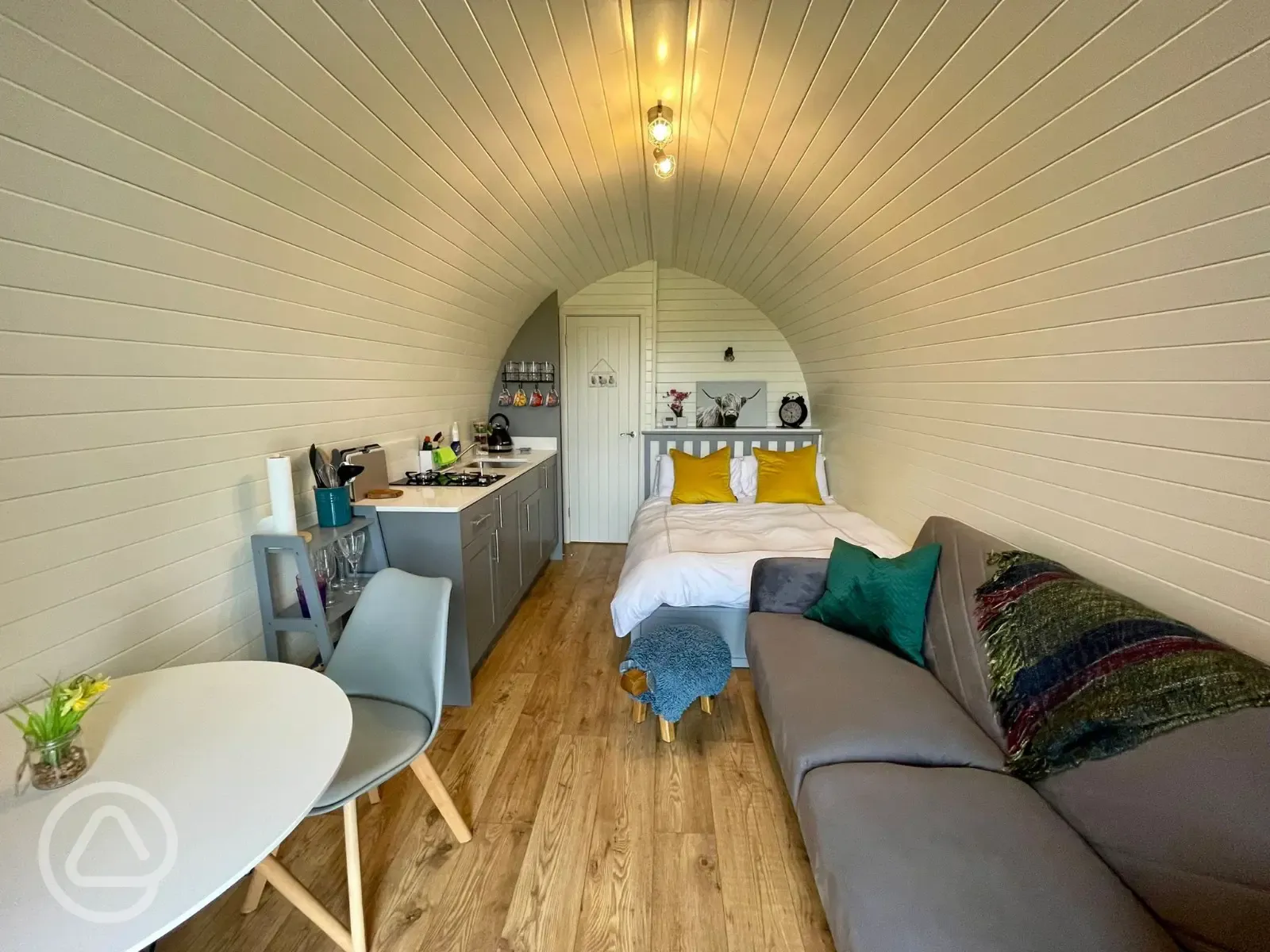 Luxury ensuite glamping pod with a double bed, dining space, sofa, and kitchen