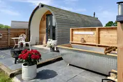 Luxury ensuite glamping pod with outdoor bath, fire pit, and seating